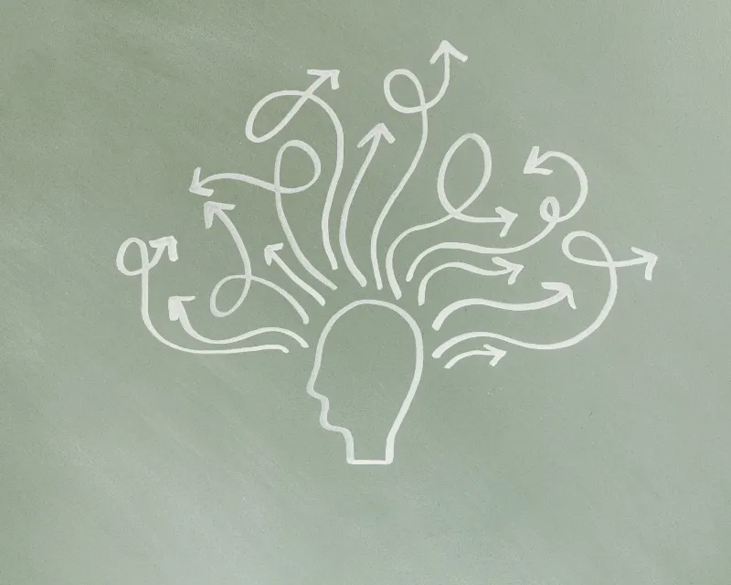 an outline of a head profile with lots of arrows coming out of the top in different directions and swirls representing the chaos of AuDHD