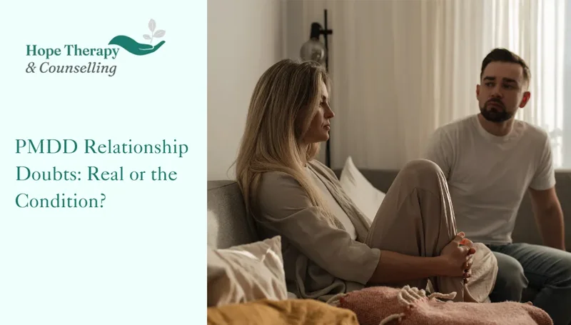 a couple sat in a living room on the sofa after a discussion the representing the experience of PMDD relationship doubts and the uncertainty they bring
